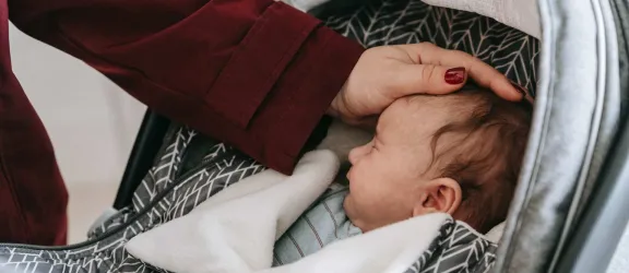 Frau mit Hand auf Babykopf